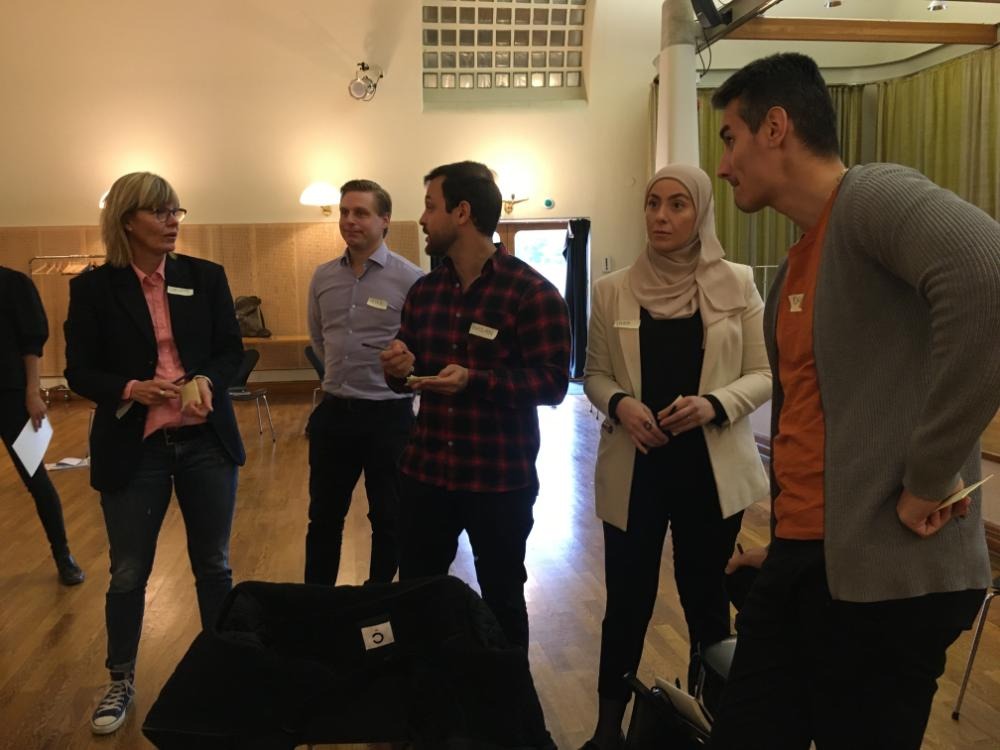 Bild på deltagare i projektet som står och diskuterar med varandra. 